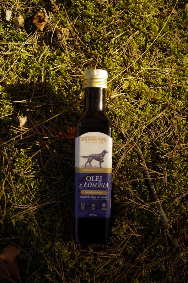 Butelka oleju z łososia w trawie